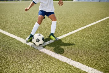 Futbol uygulama açık havada sırasında topu tekmeleme tanınmaz halde genç çocuk portresi düşük bölümü