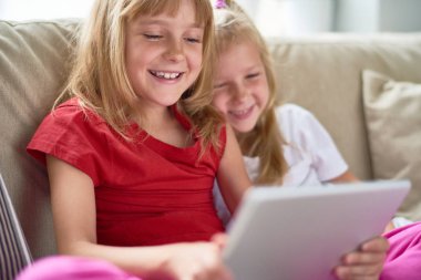 Neşeli küçük kız bir oturma odası ve dijital tablet en sevdiğim çizgi filmler izlerken araya