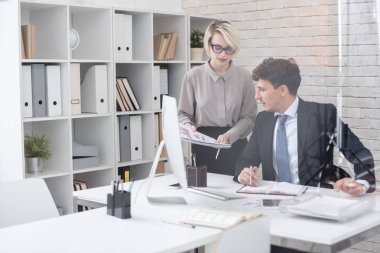 Patron ona kağıtları, kopya alanı teslim Sekreteri ile cam duvarın arkasında modern ofis masasında oturan portresi