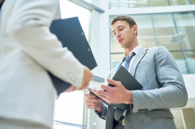 Yakışıklı genç işadamı ofis lobisinde kayıt dışı çalışma toplantısı yaparken kadın meslektaşım için fikirler sunan düşük açılı görünüş