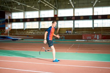 Yan görünüm portre amputee sporcunun kapalı Stadyumu Paralimpik şampiyonluk için hazırlanıyor kavramını üzerinde çalışan