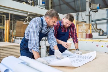 İki işçi atölye modern sanayi fabrikası, kopya alanı proje planında tartışırken portresi