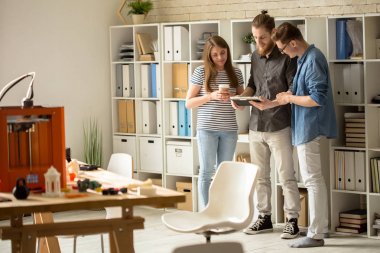Başarılı iş arkadaşları için açık plan office, 3d printerlere harcama maddeler ve küçük prototip masanın üzerinde bulunan resmi olmayan toplantı yaparken sonuçlar yakışıklı sakallı Tasarımcısı