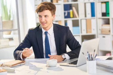 Modern ofis masasında çalışan başarılı genç işadamı portresi
