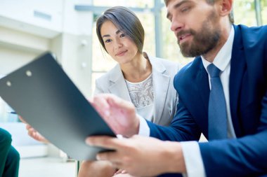 Orta yaşlı Yöneticisi o ilgi ile onu dinlerken çok kadın meslektaşı ile iş fikirleri paylaşırken Pano elinde tutan sakallı