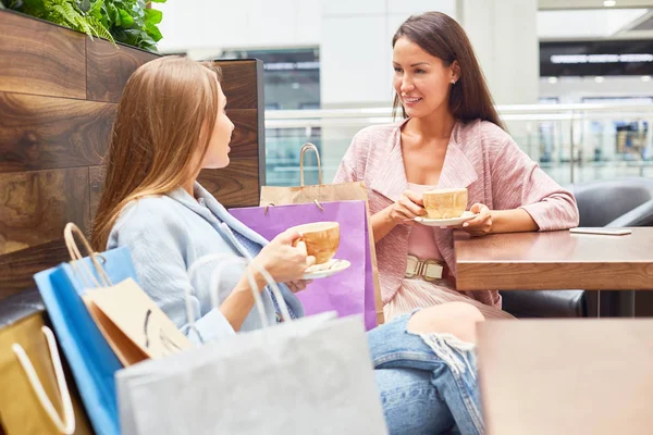 Bevásárlóközpontban Beszélgetni Kávét Iszik Kávézó Asztal Körül Papírzacskó Két Gyönyörű — Stock Fotó