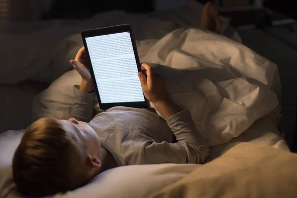 Retrato Alto Ángulo Del Niño Leyendo Libro Cama Usando Reader — Foto de Stock