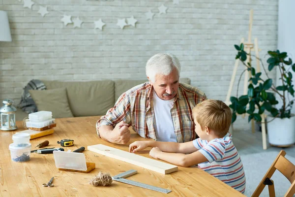 祖父と孫木工を教える古い男は小さなスタジオで話しデスク木製モデルながら少年の肖像画 — ストック写真