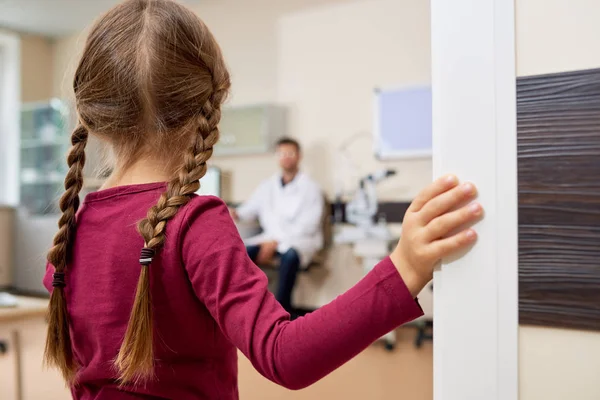 Widok Tyłu Portret Przestraszona Dziewczynka Wprowadzania Biurze Lekarzy Stojąc Drzwiach — Zdjęcie stockowe