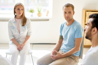 Grup oturumu sorun paylaşımı daire içinde oturan diğer katılımcıların dikkatle dinlemeye modern genç adam portresi