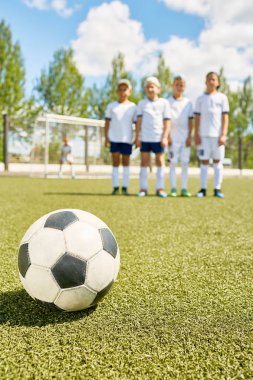 Closeup futbol topu ile takım arka planda yeşil çim üzerinde yalan