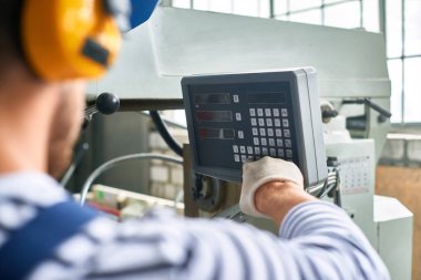 Elektronik kontrol panelinden makinesi ünite modern fabrikasında çalışırken düğmelere işçi closeup