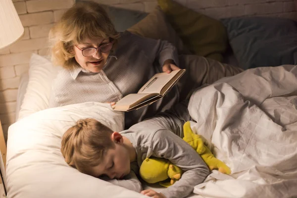 Portrait Smiling Grandmother Wearing Glasses Reading Bedtime Stories Sleeping Little — Stock Photo, Image