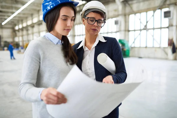 Nadenkend Vrouwelijke Bouwondernemer Brillen Aanbevelingen Geven Aan Jonge Vrouwelijke Ingenieur — Stockfoto