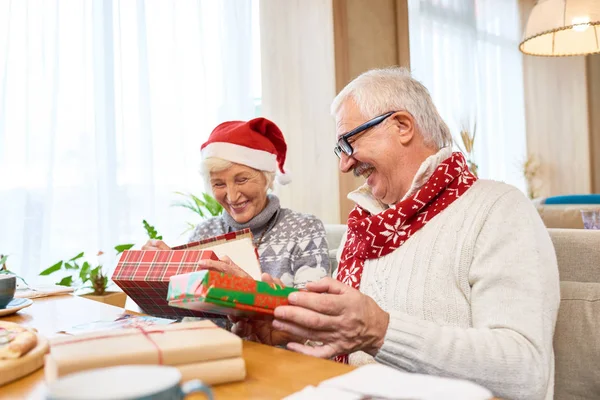 Portrait Loving Senior Couple Unwrapping Christmas Presents Laughing Happily Sitting — Stock Photo, Image