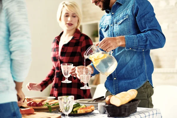 Young Man Pouring Refreshing Lemonade Glasses Standing Big Table Food — Stock Photo, Image