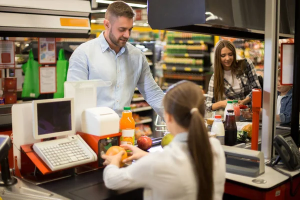 Portret Van Lachende Jongeman Voedsel Kopen Supermarkt Kijken Kassier Prijzen — Stockfoto