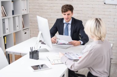 Pazarlama stratejisi ve istatistik raporları tartışırken Yöneticiler toplantı sırasında masada oturan yakışıklı işadamı portresi