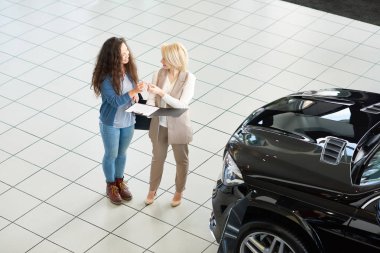 Genç danışman geçen kalem başarılı anlaşma araba showroom sonra sözleşme imzalamak için karma yarış müşteriye yüksek açılı görünüş