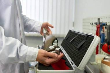 Tanınmayan prosthetist modern laboratuarda çalışırken koruyucu durumda yeni bacak protezi koyarak, yakın çekim