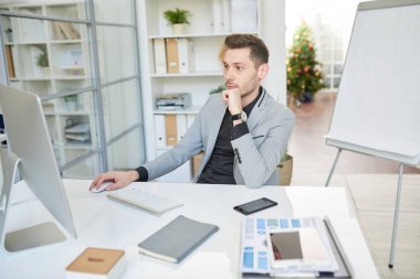 Masada oturan ve Office Internet araştırma yaparken bilgisayar kullanarak modern iş Yöneticisi portresi