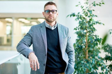 Kameraya bakarak ve balkon korkuluk üzerine eğilerek ofis binası poz modern işadamı portresi kadar bel