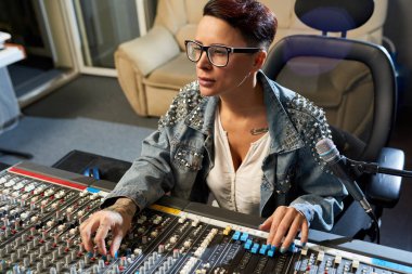 Düşünceli modern kadın ses mühendisi Fader taşıma ve Ssl kanalları dijital ses kanal karıştırıcı Studio büküm süre sesler karıştırma üzerinde konsantre