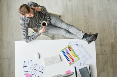 Doğrudan alan genç adam içme kahve renk şemaları ve iç tasarım planlama mola rahatlatıcı bir görünümünü, kopyalama