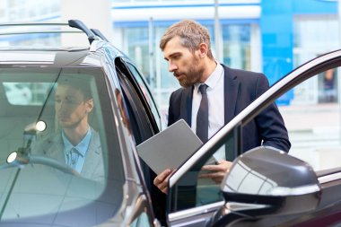 Lüks araba showroom satış müdürü ile içinde oturan test sürüşü için alarak yakışıklı genç adam portresi