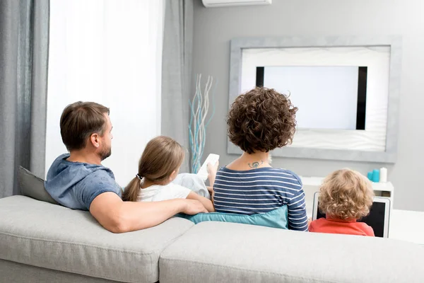 Visão Traseira Retrato Família Com Dois Filhos Assistindo Sentado Sofá — Fotografia de Stock