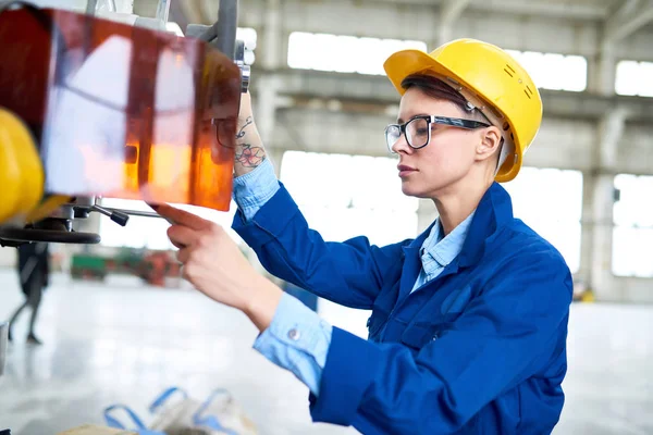 近代的な工場で働きながらコントロール パネルのプッシュ ボタンの女性工場労働者の側ビュー肖像画 — ストック写真