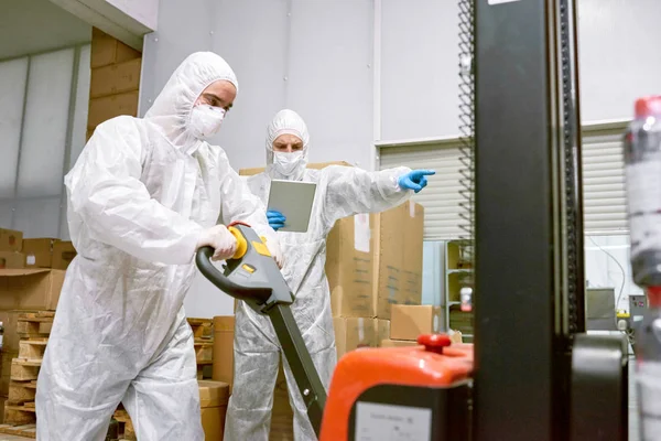 Concentrated Young Worker Wearing Coverall Safety Mask Using Hand Pallet — Stock Photo, Image