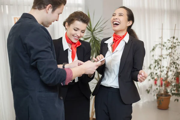 Portrait of three carefree office workers laughing while chatting in modern office