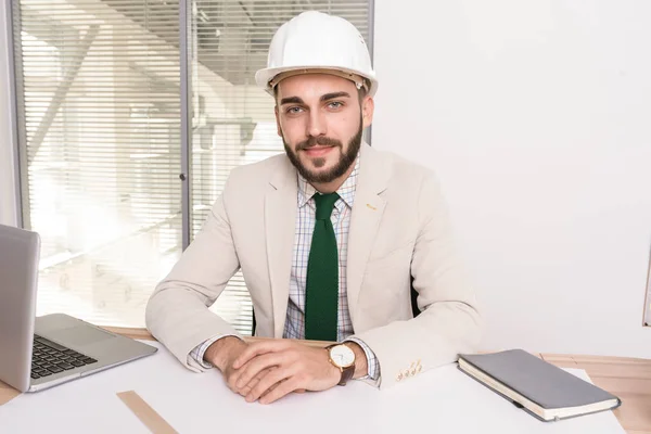 Retrato Belo Jovem Engenheiro Vestindo Chapéu Branco Sentado Mesa Com — Fotografia de Stock