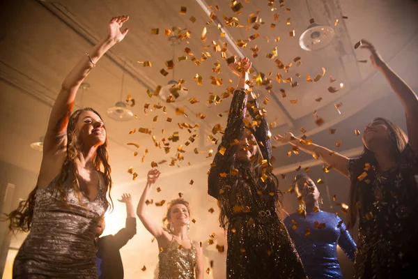 一群美丽的年轻女子在金色的五彩纸屑下跳舞 在夜总会尽情狂欢 低角度 — 图库照片