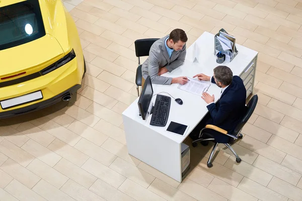 View Young Handsome Man Reading Purchase Contract Sitting Desk Dealership — Stock Photo, Image