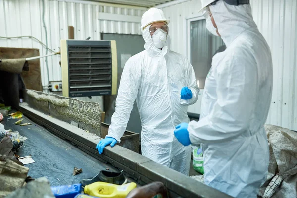 Portrait Two Workers Wearing Biohazard Suits Communicating Standing Conveyor Belt — Stock Photo, Image