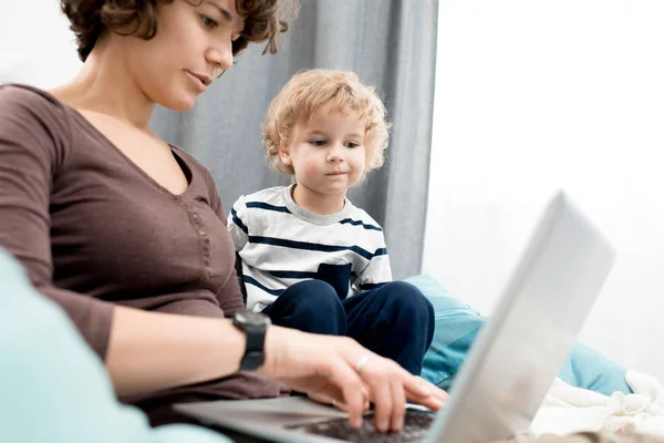 Retrato Jovem Mãe Usando Laptop Casa Foco Menino Curioso Olhando — Fotografia de Stock