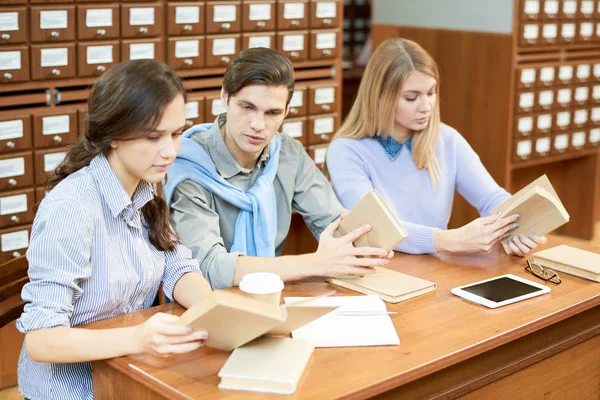 Três Colegas Grupo Sentados Mesa Madeira Biblioteca Espaçosa Envolvidos Fazer — Fotografia de Stock