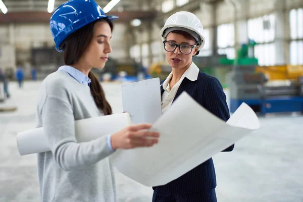 Portret Dwóch Kobiet Inżynierów Noszenia Budowlani Zbadanie Planów Pracy Warsztacie — Zdjęcie stockowe