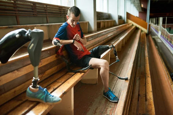 Портрет Молодого Инвалида Сидящего Скамейке Современном Стадионе Проверяющего Фитнес Трекер — стоковое фото