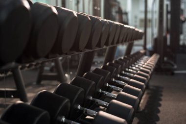 Arka plan görüntüsü dumbbells ekipman düz satırlarının stand modern spor salonu, kopya alanı