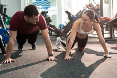 Sportif çift zevk modern spor salonunda eğitim ve gülümseyerek, birbirine bakarak portresi
