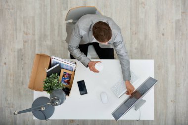 Tanınmayan Yöneticisi görünümünü el Ofis Masası oturma ve kutusu ile onun aidiyet ayakta onu yanında modern bilgisayar açma kahve fincan kağıt üstünde