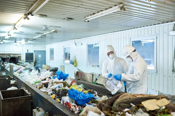 バイオハザードを着て 人の労働者の肖像画のスーツで廃棄物処理工場のコンベア ベルト コピー領域の分別作業 — ストック写真