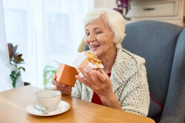 Hermosa Anciana Con Sonrisa Dentada Abriendo Una Pequeña Caja Regalo — Foto de Stock