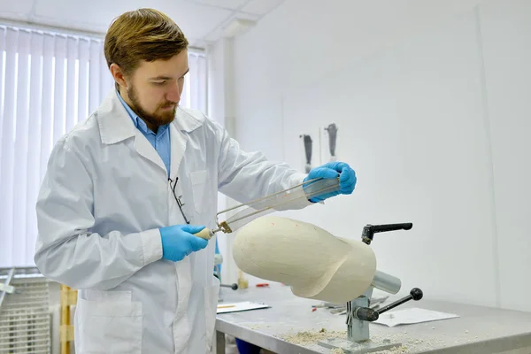 Retrato Del Joven Técnico Prótesis Lijando Molde Prótesis Mientras Trabaja — Foto de Stock