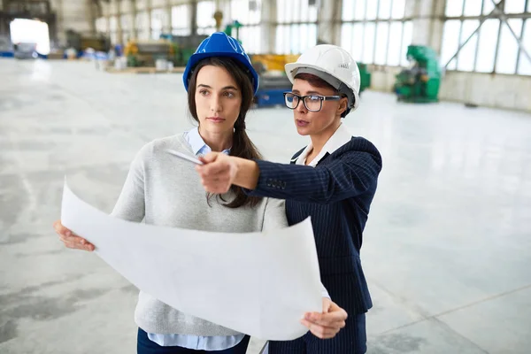 Portret Dwóch Młodych Inżynierów Kobiet Noszenie Budowlani Planowanie Planów Pracy — Zdjęcie stockowe