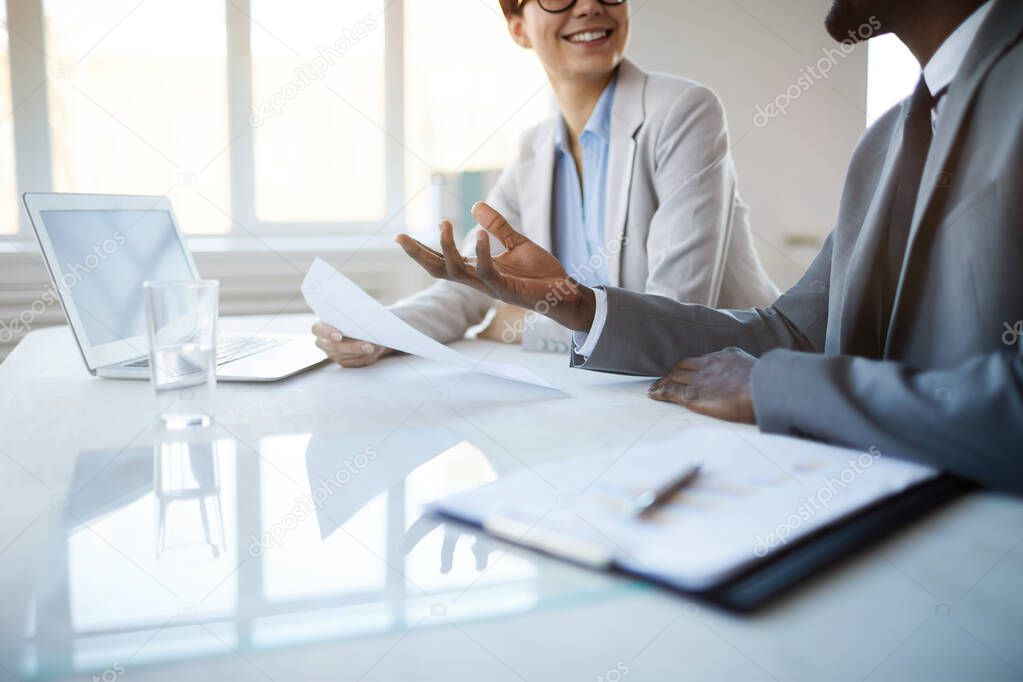 Cropped portrait of successful business team gesturing actively while discussing project at meeting table, copy space
