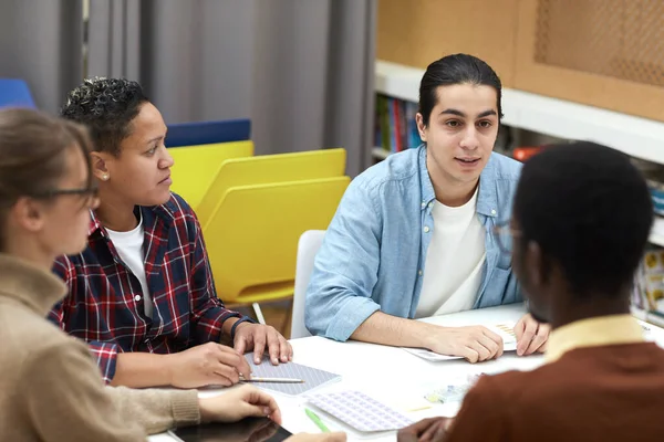 Multi Ethnic Group Students Sitting Table College Library Discussing Project — ストック写真